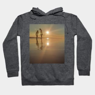 Silhouetted people in a row on a sand beach. Hoodie